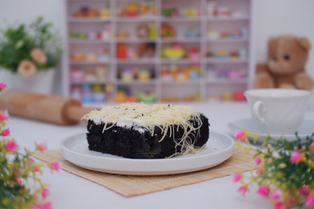 A piece of black cake topped with shredded cheeseの写真素材