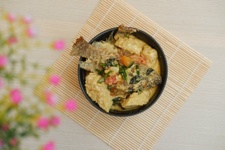 Fried fish with curry in a bowl on a wooden table.の写真素材