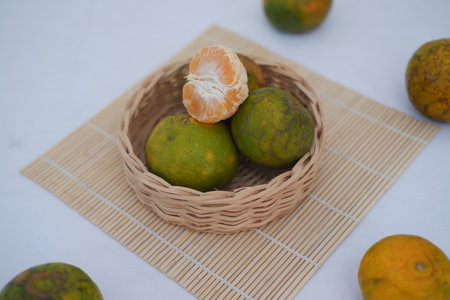 Orange fruit in basket on bamboo mat. Selective focus and shallow depth of field.の写真素材
