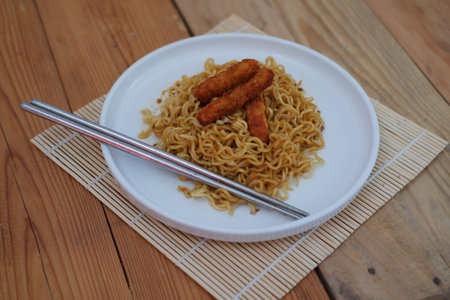 A plate of noodles topped with nugget, creating a delicious and colorful meal.の写真素材