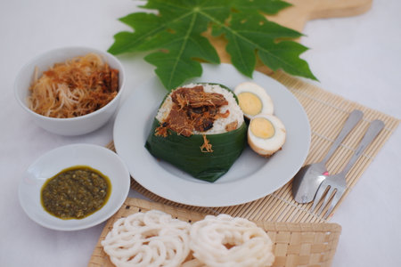 rice with meat, egg, crackers, sambal and noodles on a white backgroundの写真素材