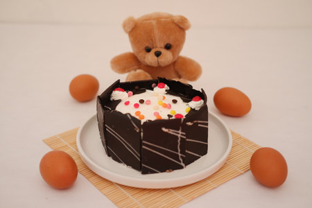 Cake with cherry on top and eggs on a bamboo matの写真素材