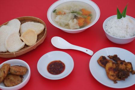 traditional Indonesian food arranged neatly on a red surfaceの写真素材