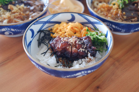 Each bowl contains different ingredients such as meats, vegetables, and rice, garnished with green herbsの写真素材