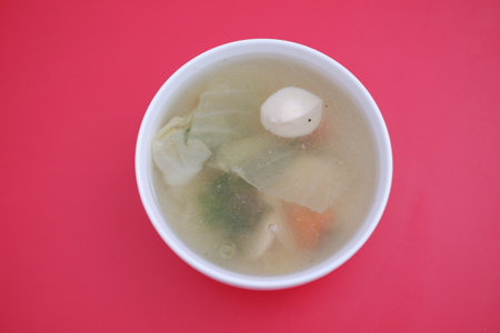 A bowl of soup on a red tableの写真素材