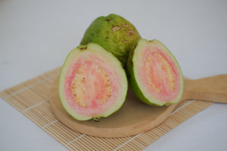 Fresh guava fruit cut in half on cutting boardの写真素材