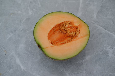half cantaloupe melon on a marble backgroundの写真素材