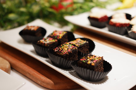 small cupcakes topped with frosting and colorful sprinklesの写真素材