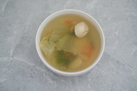 A bowl of fresh soup on a tableの写真素材