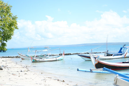 Quiet Beach with Traditional Boat and Clear Blue Watersの写真素材