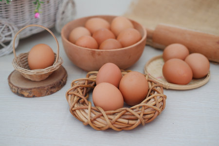 egg in wooden bowl and basket on a white backgroundの写真素材