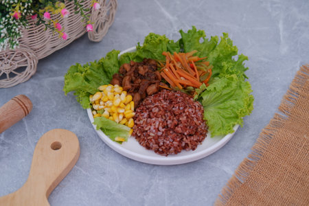 A vibrant meal consisting of red rice, meat, corn, carrots, lettuce.の写真素材