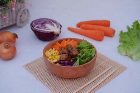 A vibrant meal consisting of red rice, meat, corn, carrots, lettuce, and a sunny sideの写真素材