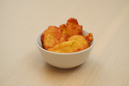Corn croquettes in a bowl on a wooden tableの写真素材