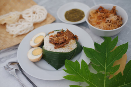 rice with meat, egg, crackers, sambal and noodles on a white backgroundの写真素材