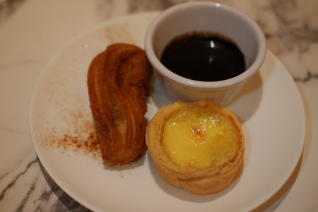 Delicious Dessert Trio with Churros, Custard Tart, and Chocolate Dipの写真素材