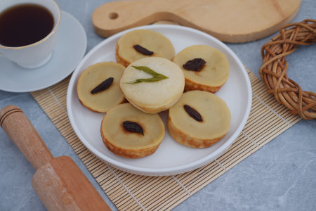 Kue Lumpur or Mud Cake, Indonesian traditional cake made from potato, flour, eggs and coconut milk topped with raisins served on plate. beautiful decorationの写真素材