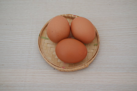 Fresh Brown Eggs on a Traditional Bamboo Basketの写真素材