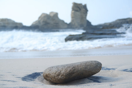 A Silent Stone Amidst the Rolling Wavesの写真素材