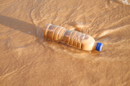 plastic bottle lying on a sandy beachの写真素材