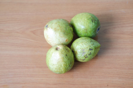 four guavas placed on a wooden surfaceの写真素材