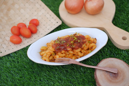 a plate of macaroni pasta served with a rich tomato based sauceの写真素材