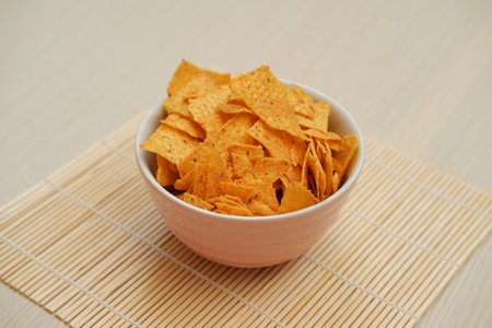 This image features a bowl of crispy orange tortilla chipsの写真素材