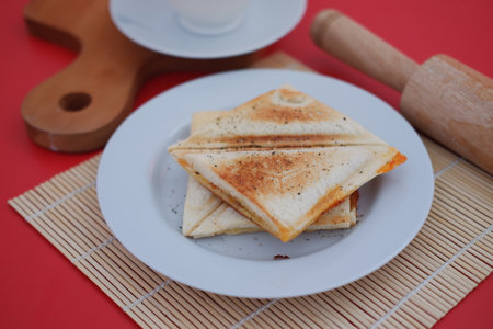 a plate of toasted sandwich triangles neatly stacked on a white plateの写真素材