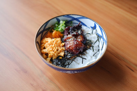 a beautifully presented bowl of Japanese-style rice topped with a variety of colorful and appetizing ingredientsの写真素材