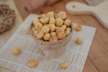 a woven bamboo basket filled with small, round cheese puffs or savory snack ballsの写真素材