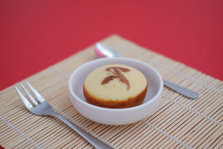 a single round sponge cake served in a white bowlの写真素材