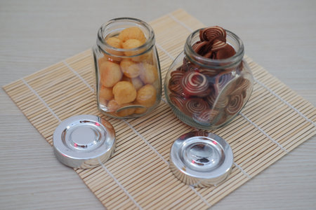 two small glass jars placed on a bamboo matの写真素材