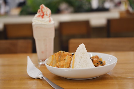 a triangular mound of steamed white rice paired with crispy fried chicken pieces topped in a rich, orange creamy sauce, possibly a cheese or spicy mayo blendの写真素材