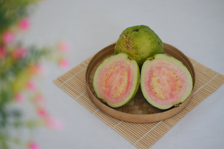 holding a whole guava and a guava that has been cut in halfの写真素材