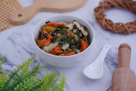 a bowl of mixed stir-fried vegetables served in a clean white bowlの写真素材