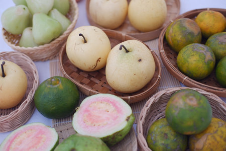 an assortment of fresh fruits beautifully arranged in small woven baskets on a bamboo matの写真素材