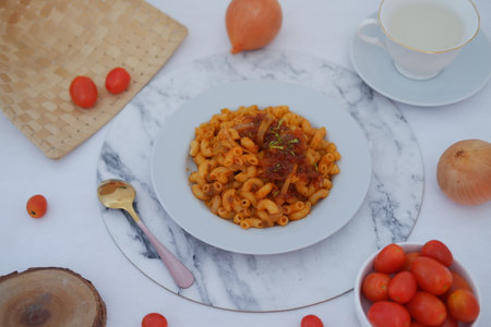 Macaroni Pasta with Tomato Sauce, Cherry Tomatoes, and Onionの写真素材