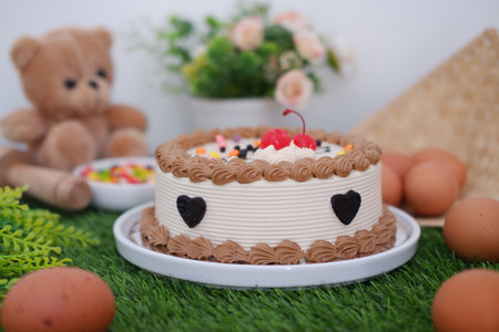 Delicious Birthday Cake with Cherries and Chocolate Decorationの写真素材