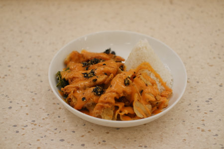 Delicious Chicken Dish with Orange Curry and Riceの写真素材
