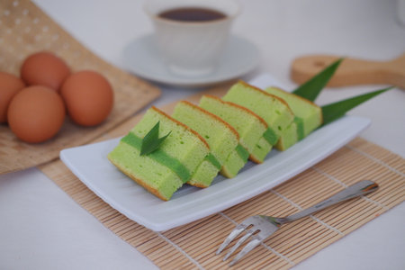 Delicious Layer Cake with Pandan Flavor and Coffee on the Sideの写真素材