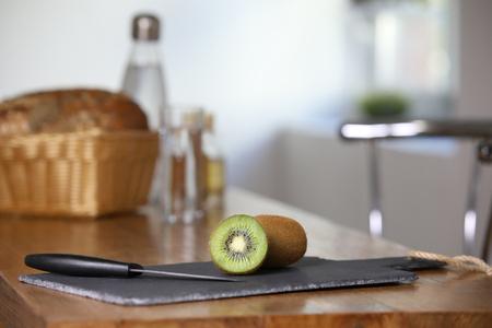 Sliced kiwi on a slate in the kitchenの写真素材