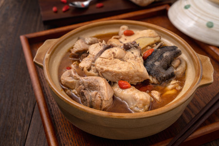 Taiwanese food-Homemade delicious sesame oil chicken soup in a bowl on dark wooden table background.の写真素材