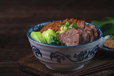 Taiwanese famous food beef noodle with sliced braised beef shank, tripe and vegetables on wooden...