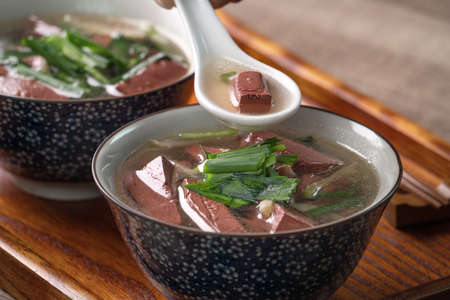 Eating pig blood soup, homemade Taiwanese traditional food with pickled mustard greens and garlic...