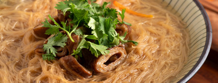 Homemade delicious large intestine vermicelli thin noodles in a bowl on dark wooden table...