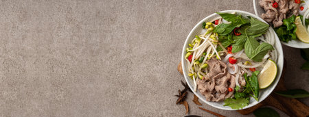 Top view of delicious vietnamese beef noodles pho in a bowl with ingredients with copy space.