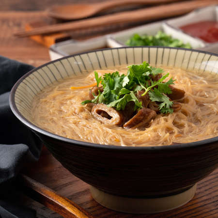 Homemade delicious large intestine vermicelli thin noodles in a bowl on dark wooden table background.の写真素材