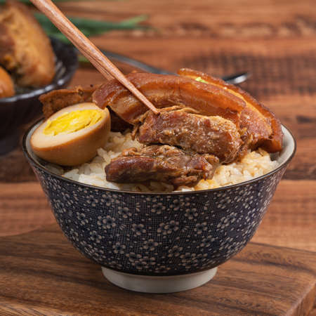 Braised pork belly, close up of stewed pork chop over cooked rice in Taiwan. Taiwanese famous traditional street food delicacy.の写真素材