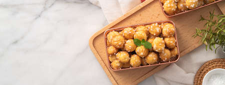 Top view of delicious French Chouquette Choux Pastry dessert Pearl Sugar Puff in a basket on white...