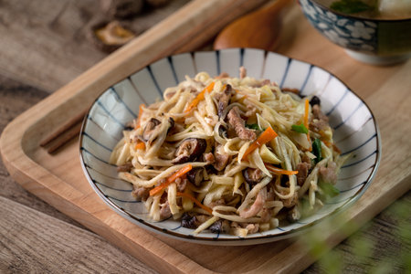 Pork meat julienne fried with water bamboo shred. Close up of delicious homemade food on wooden table background.の写真素材